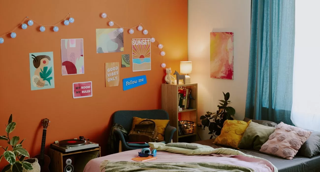 Quarto personalizado com parede laranja.