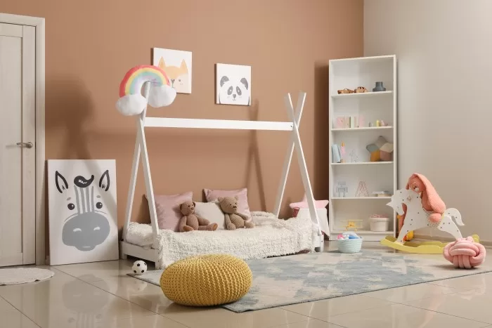 Quarto personalizado infantil com cama montessoriana, prateleiras e brinquedos.
