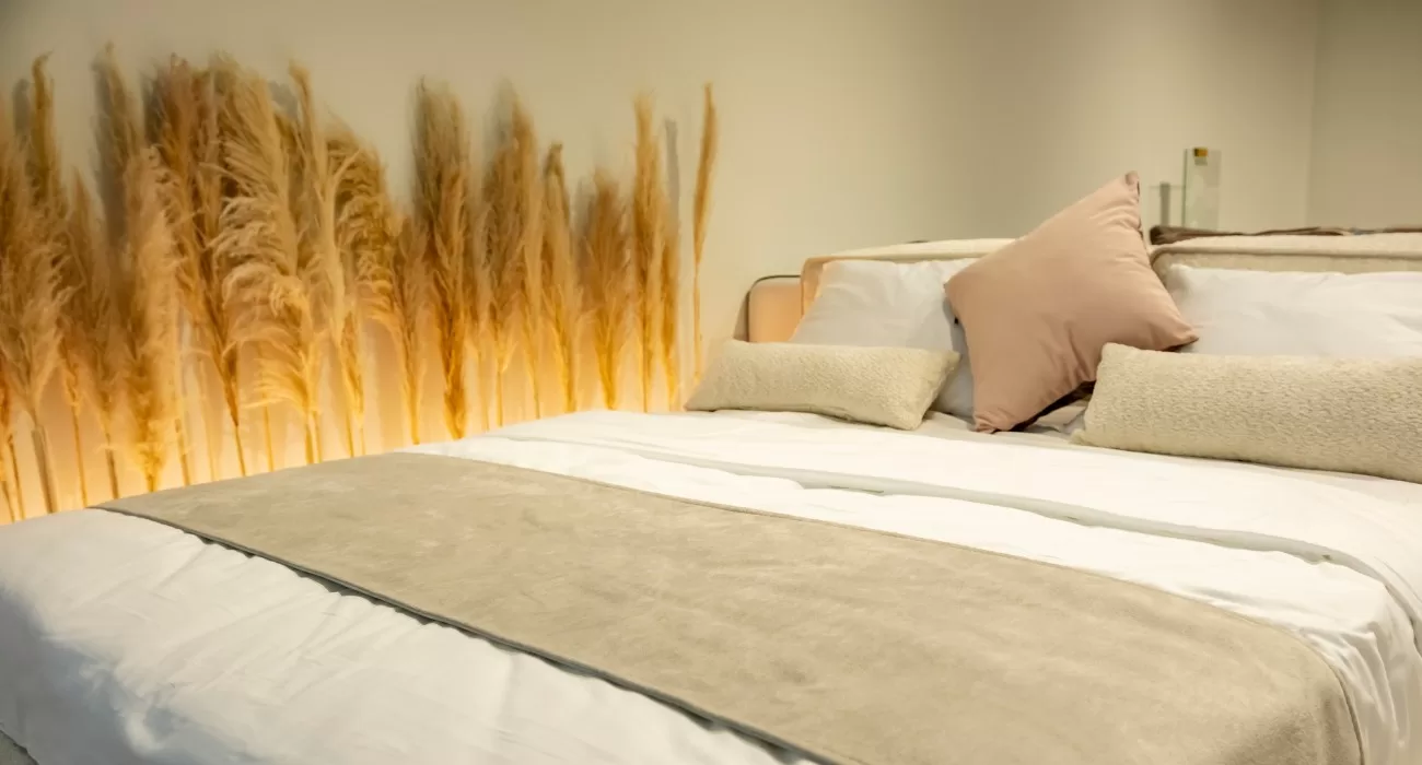 Cama posta com lençol, edredom e cobre leito.