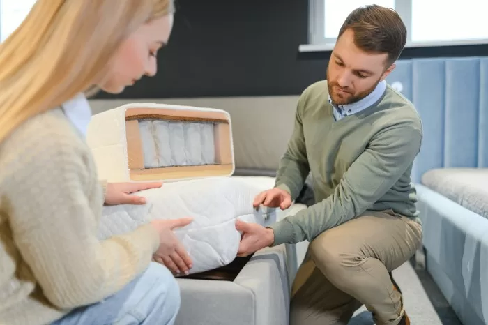 Pessoas olhando modelo do colchão para realizar giro.