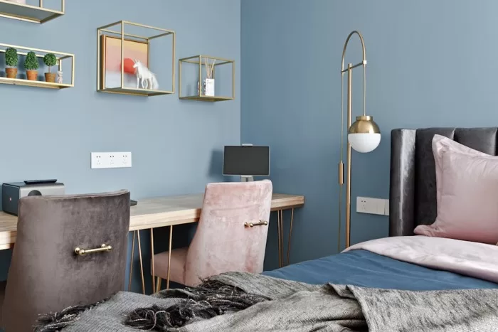 Quarto de adolescente pintado de com parede azul.