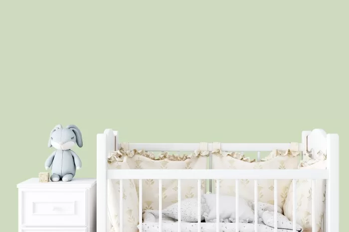 Quarto de bebê pintado de com parede verde.