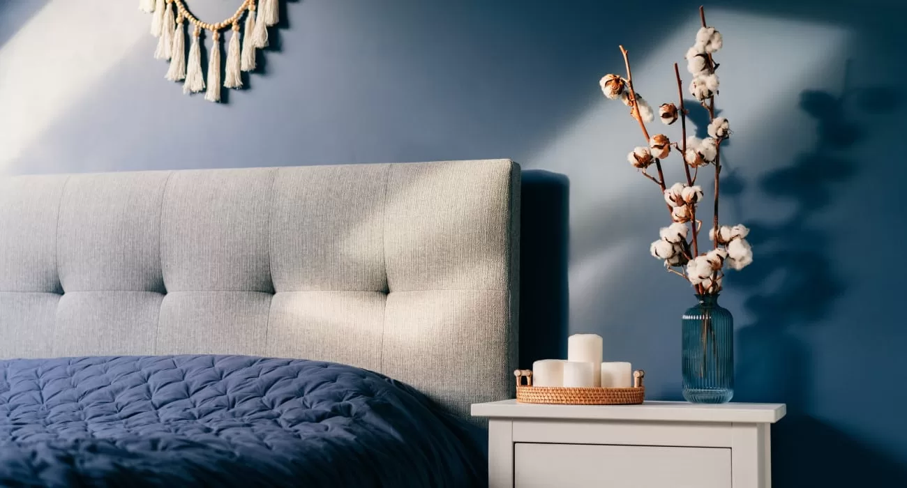 Quarto azul com detalhes em branco na decoração.