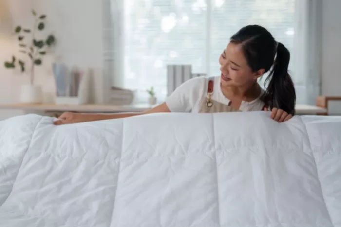 Uma mulher olhando e segurando um colchão