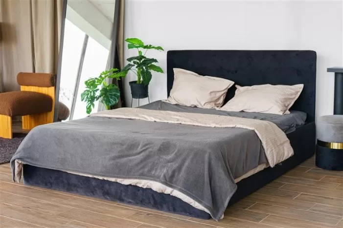 Uma cama de casala arrumada em um quarto decorado