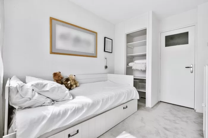 Um quarto de solteiro branco bem planejado