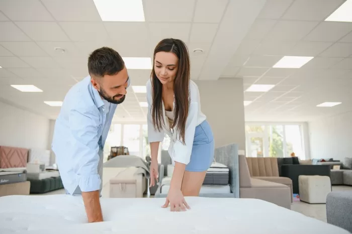 Casal sentindo o toque de um colchão ortopédico.