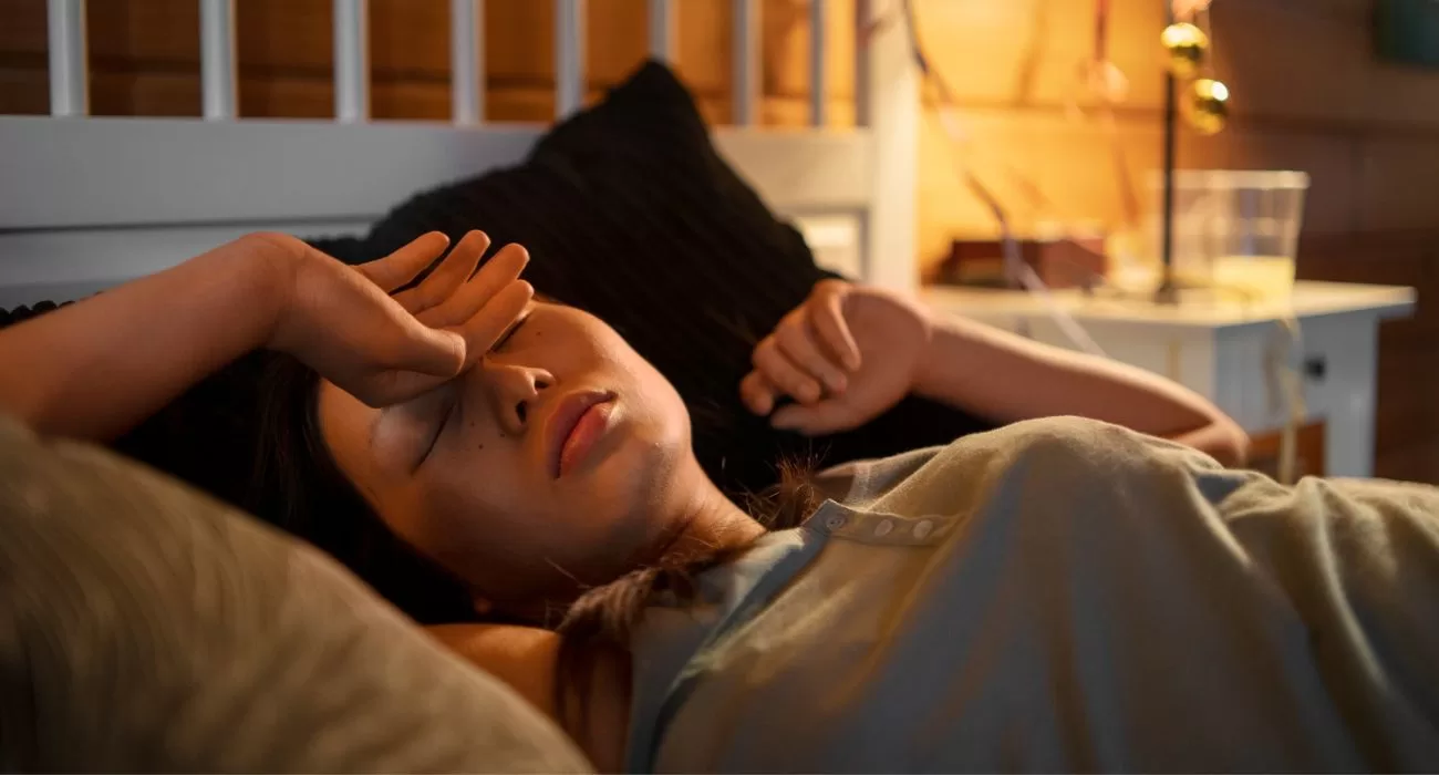 Mulher deitada dormindo em um ambiente confortável, pois entende a importância do sono.