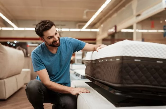 Homem escolhendo colchão mais adequado para seu biotipo físico.