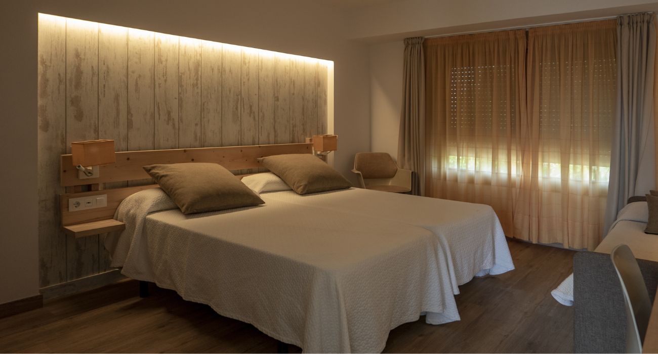 Quarto arrumado com luzes indiretas.